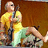 Pixelated image of a person in yellow top and light green pants holding a dark object against brown background.