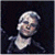 A 50x50 pixel animated buddy icon featuring a person with light hair and dark clothing on the left, next to green text reading "Original Icons .com" on a dark background.