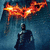 Batman stands in a dark blue misty background with an orange-yellow bat symbol above him, the symbol flickering between two distinct flame-like states.