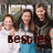 Group of six people in casual clothing posing together with text overlays reading 'besties' and 'rock!' on a blurred background.