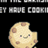 Pixelated cookie icon with a smiling face, brown chocolate chips, and pink cheeks on black background.