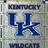 Static pixelated image showing large blue 'UK' letters on a light gray background with partial dark text above and below.