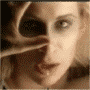 A pixelated close-up of a person's face with flowing hair, showing two sequential expressions in warm sepia tones.