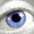 A close-up of a blue eye with white sclera and eyelid, set against black background text reading 'I'M WATCHING YOU' in pixelated font.