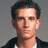 Pixelated image of a person with dark hair and a black jacket over a white shirt on a gray background, next to blue background with text.