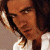 A pixelated image of a person with long dark hair wearing a white shirt, positioned next to green text reading 'Original Icons .com' on a solid background.