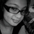 Pixelated grayscale portrait of a person with dark hair and glasses, wearing a light-colored top against a dark background.