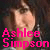 Pixelated image of a person with light skin and brown hair, overlaid with bright pink text reading 'Ashlee Simpson' in blocky font.