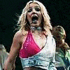 Britney Spears in a red and white crop top with denim jacket, performing on stage with dynamic poses and expressive gestures.