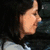Two people in close proximity, one holding a white cloth near the other's face, with dark hair and light-colored clothing visible.