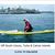 Pixelated image of a person standing on a yellow line near water with buildings in the background.