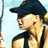 Pixelated static image of a person in profile wearing a black cap and dark sleeveless top against light blue background with partial yellow object on right edge.