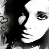 Black-and-white close-up of a person's face with dark hair, two heart symbols on the left side, and high-contrast lighting.