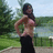 Pixelated image of a woman in a red top and black skirt standing outdoors with hands on hips, next to red pixelated text on black background.