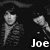 Black-and-white pixelated image of two figures in striped jackets with text labels and a heart symbol.