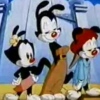 Three cartoon characters stand side-by-side against a blue background with white clouds; the central figure holds a brown object.