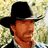 Pixelated image of a man in a black cowboy hat and striped shirt against blurred foliage, with green text on dark green