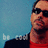 Pixelated image of a person wearing dark sunglasses and red clothing against a blue background with partial text.