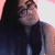 Pixelated image of a person with long dark hair wearing a dark sleeveless top against a light background.