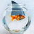 A pixelated goldfish swims inside a glass bowl with blue accents, viewed from above against a light background.
