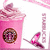 A pink cup with a circular brown and purple pattern on its side, topped with swirled pink cream and a small leaf-shaped garnish.
