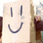 A person in a brown shirt and blue jeans holds two large smiley face signs, with text below reading 'I luv boxman!!' and '<333333'.