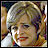 Pixelated static image of a person with light-colored hair and red lips, wearing a white top against a multicolored background.