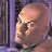 Pixelated close-up of a bald character's head with closed eyes and a neutral expression against a purple background.