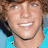Two identical pixelated images of a smiling person with brown hair and light blue shirt, side-by-side on a light blue background.
