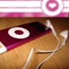 A static image shows a dark red rectangular device with a white circular target symbol on a wooden surface, accompanied by white earphones and a pink striped banner with a heart icon.