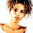 Pixelated static image of a person with curly brown hair and light skin tone, cropped to show upper body against white background.