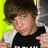 Pixelated image of a person with brown hair wearing black and white clothing against a bright yellow background, on a pink field with text.