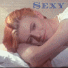 A person with light brown hair lies on a white pillow, head resting on an arm, with the word SEXY in blue text above.