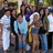 Group of people in casual clothing standing closely together with varied expressions and poses.