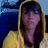A pixelated static image shows a person with long dark hair wearing a yellow hooded garment against a blue background.