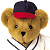 Pixelated teddy bear wearing dark blue and red cap, white jersey with black trim, against split background of white and green.