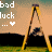 Pixelated image with text 'bad luck ...' and a heart symbol on left, featuring a figure in dark clothing leaning against a tall yellow structure under an orange sky.