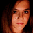 Pixelated close-up of a person with light brown hair and fair skin against dark background, static image.