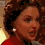 Four pixelated views of a person with curly brown hair wearing a red top and pearl earrings, arranged in a with varying head angles and expressions