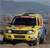 A yellow vehicle with dark windows and a blue side section appears in a pixelated image with a blurred background.