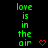 Green text 'love is in the air' repeated vertically with red pixel hearts on black background, static display.