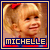 Pixelated static image of a young girl with blonde hair in pigtails wearing a red bow, smiling face, and blue border frame with text "MICHELLE" at bottom.