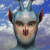 Pixelated image of a humanoid figure with a metallic helmet, green eyes, and brown ears against a blue sky with white clouds.