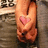 A pixelated image shows a hand with a pink heart symbol on the palm, set against a blurred background.