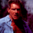 Pixelated static image of a person in a light blue shirt against dark background with red and purple tones.