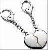 A broken heart-shaped keychain with a silver clasp and chain, displayed in showing text overlays
