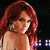 Pixelated image of a person with long red hair wearing a light-colored sleeveless top against dark background.