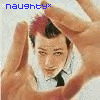 *naughty* text appears in blue at top-left; a person with short dark hair and red highlights wears a white shirt and black tie, framed by two hands forming a heart shape against a light background.