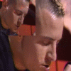 repeated close-up frames showing a person with short light hair in profile, wearing dark clothing against an orange and black background