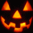 A pixelated orange and yellow pumpkin face with triangular eyes, a triangular nose, and a curved mouth against black background.